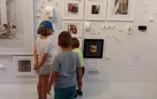 Colonias de verano en Zaragoza. Niños observando cuadros expuestos en una pared
