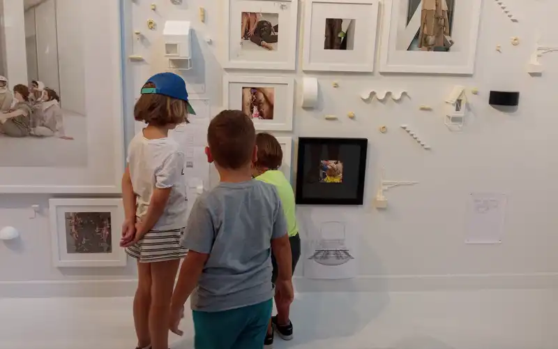 Colonias de verano en Zaragoza. Niños observando cuadros expuestos en una pared
