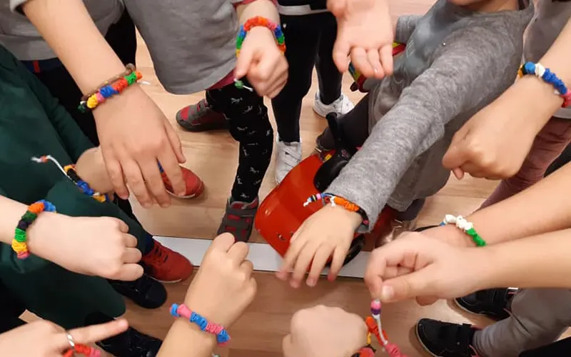 Actividades extraescolares en Zaragoza. Manos de niños en circulo simbolizando un equipo