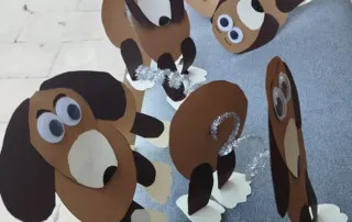 Colonia artística o tradicional. Manualidad de perros hechos con cartulina y diversos materiales