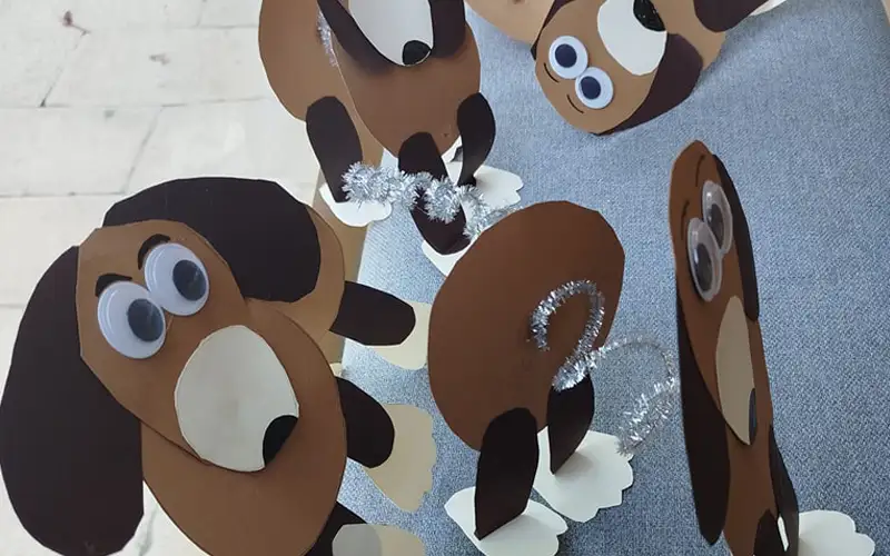 Colonia artística o tradicional. Manualidad de perros hechos con cartulina y diversos materiales