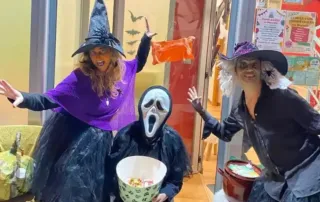 Halloween infantil Zaragoza, las integrantes de Rayuela disfrazadas de brujas en la entrada del local